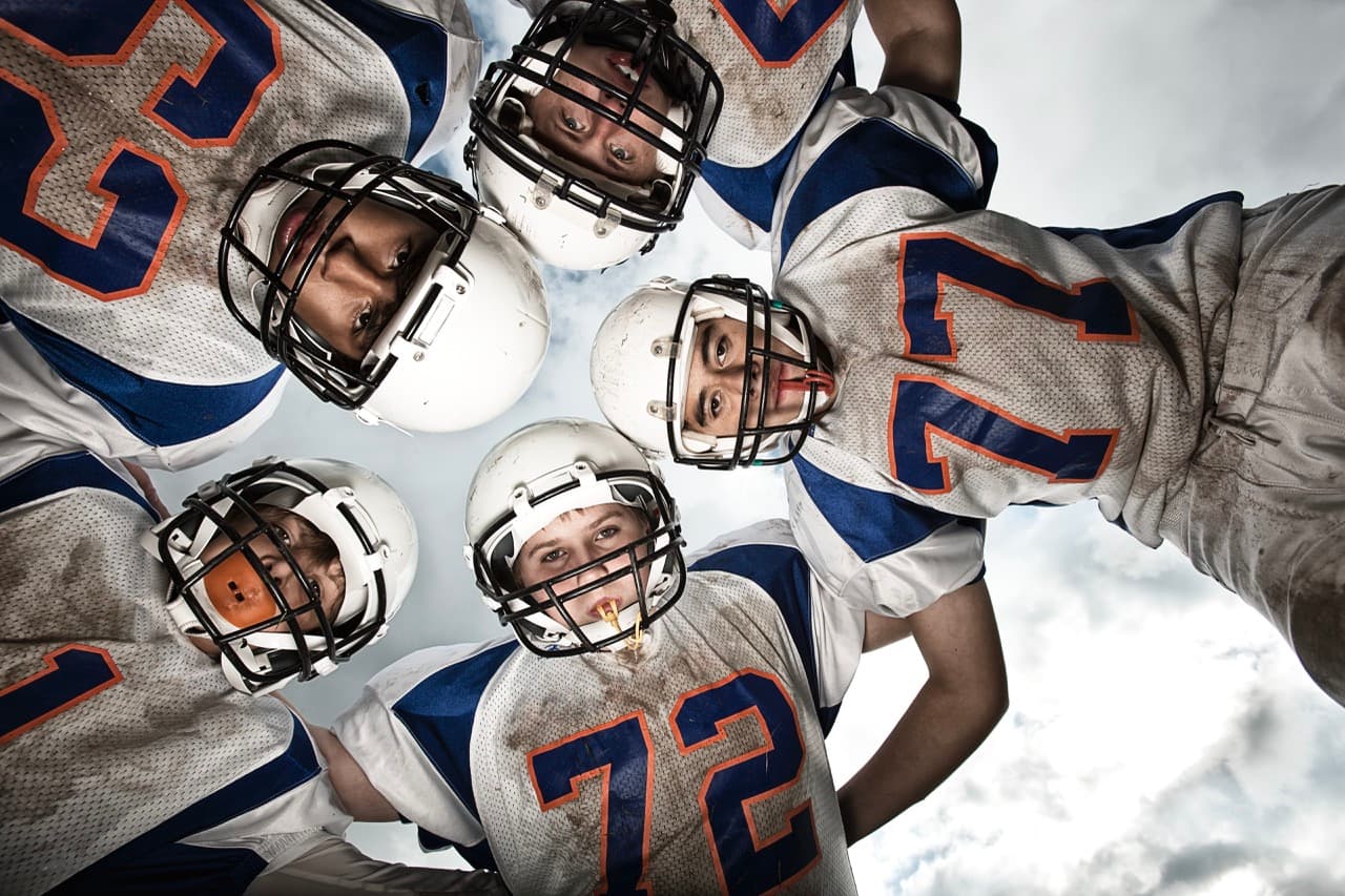 Youth football players in a team huddle